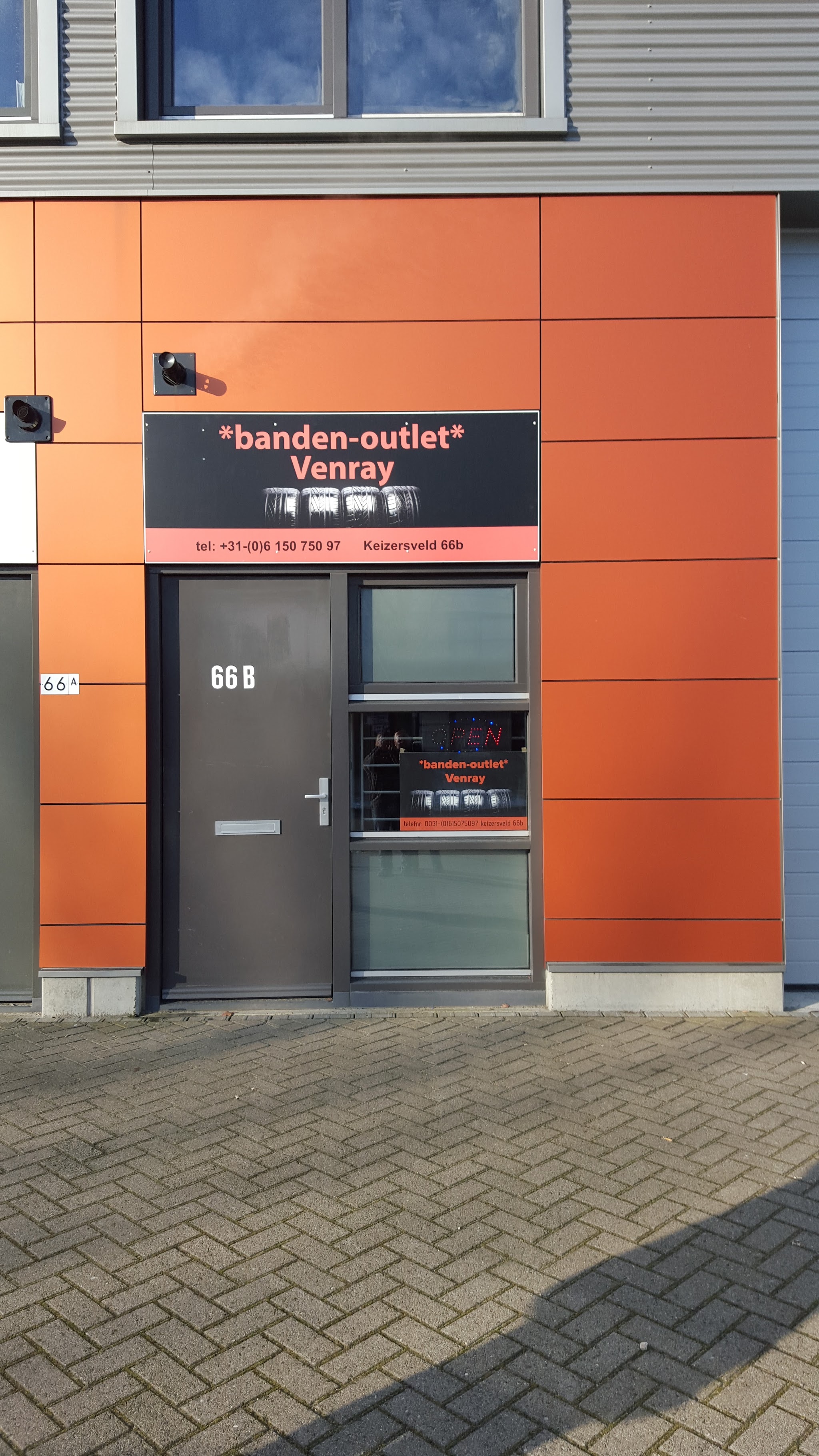 De oranje gevel van Banden Outlet Venray aan het Keizersveld 66b met het zwarte naambord